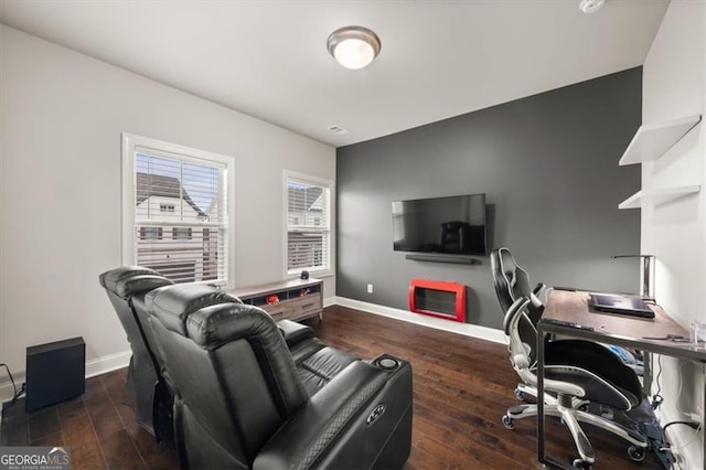 office space featuring dark wood-style floors, visible vents, a fireplace, and baseboards