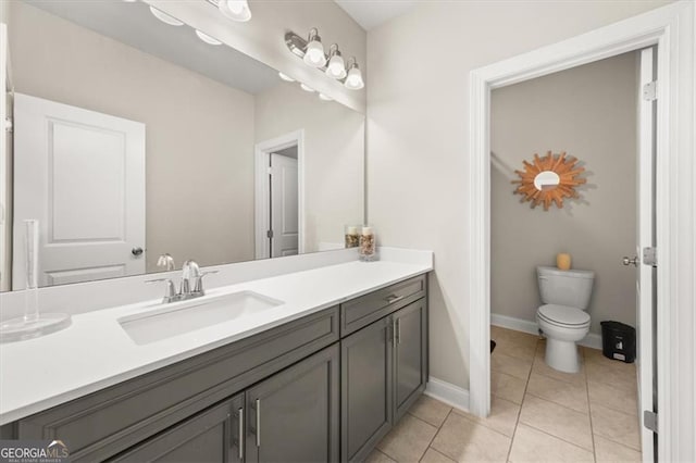 bathroom with baseboards, vanity, toilet, and tile patterned floors