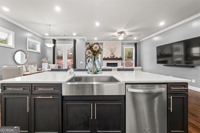 kitchen with dark wood-style flooring, decorative light fixtures, stainless steel dishwasher, ornamental molding, and a sink