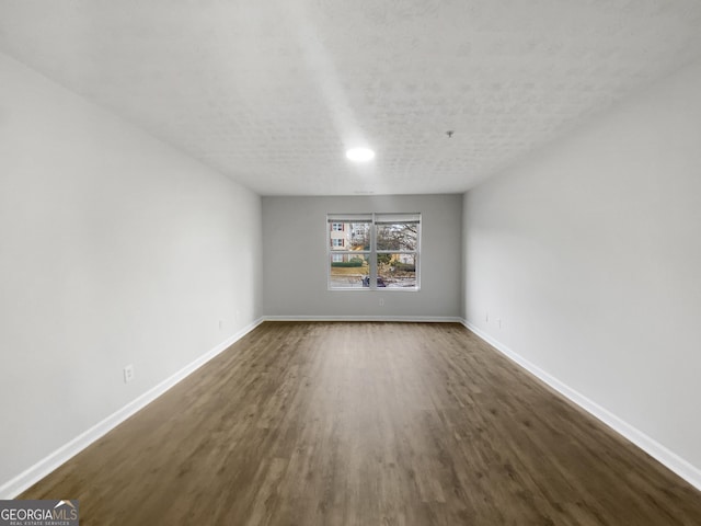 interior space featuring dark wood-style floors, baseboards, and a textured ceiling