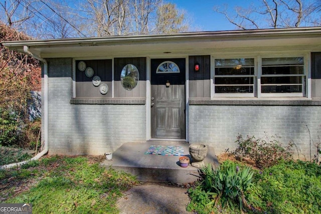 doorway to property with brick siding