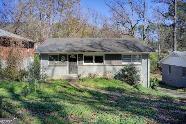 single story home with brick siding and a front lawn