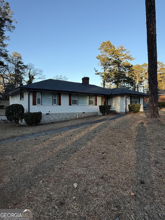 ranch-style home with a chimney