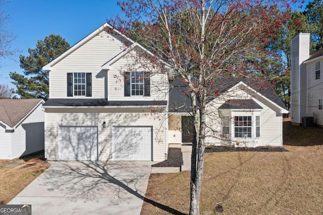 traditional-style house featuring a garage, central AC, concrete driveway, and a front yard