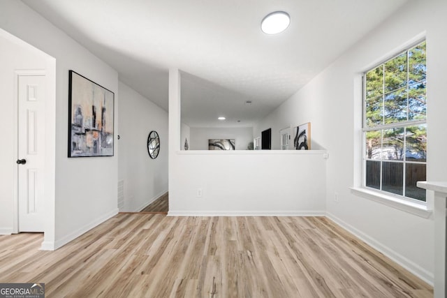 unfurnished living room featuring light wood-style flooring and baseboards