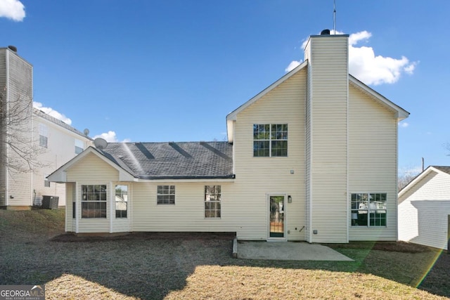 back of house featuring a patio, a yard, a chimney, and central air condition unit