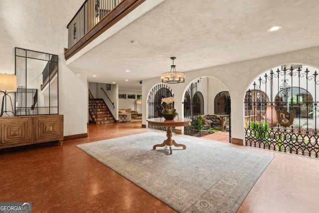 foyer with recessed lighting, a high ceiling, an inviting chandelier, baseboards, and stairs