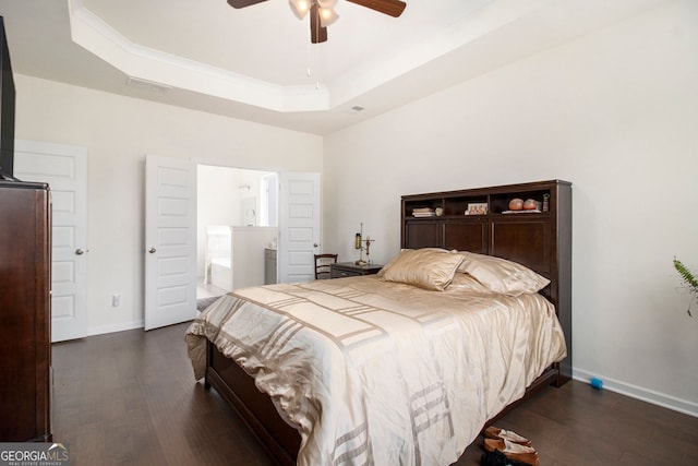 bedroom with ceiling fan, ensuite bathroom, baseboards, dark wood-style floors, and a raised ceiling