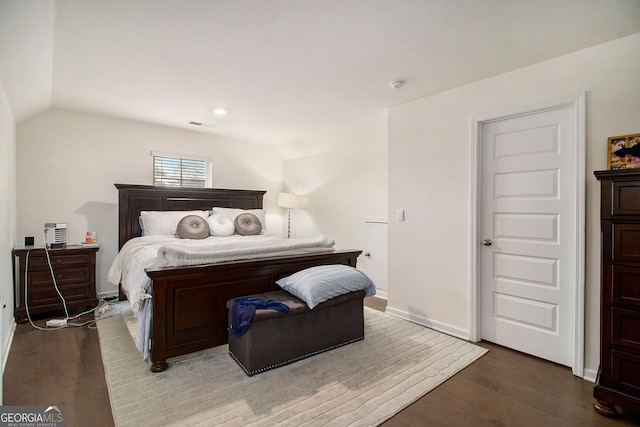 bedroom featuring lofted ceiling, baseboards, and wood finished floors