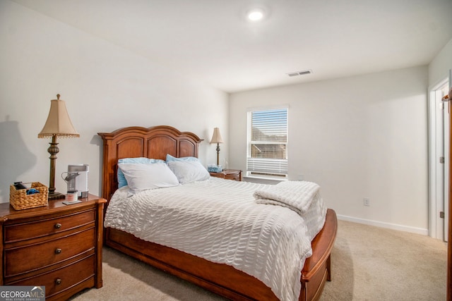 bedroom with baseboards, visible vents, and light colored carpet