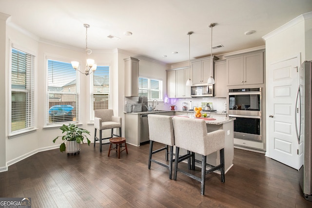 kitchen with decorative light fixtures, stainless steel appliances, visible vents, gray cabinetry, and a kitchen island