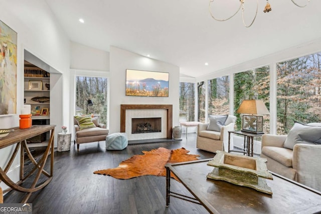 sunroom featuring a healthy amount of sunlight, vaulted ceiling, and a fireplace with raised hearth