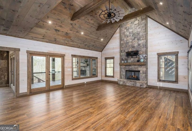 unfurnished living room with a stone fireplace, wood finished floors, wood ceiling, a ceiling fan, and beam ceiling