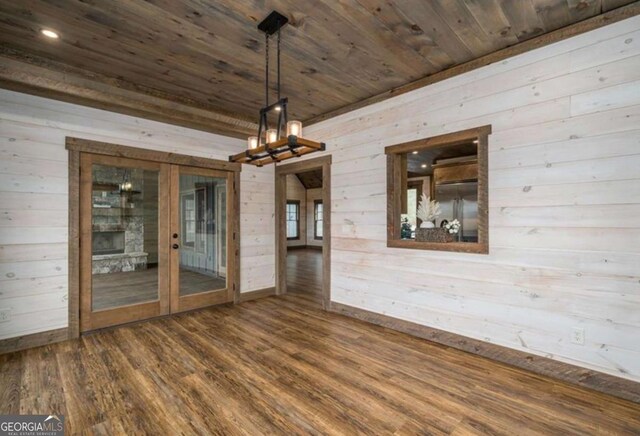 unfurnished dining area with french doors, dark wood-type flooring, wood walls, and wood ceiling