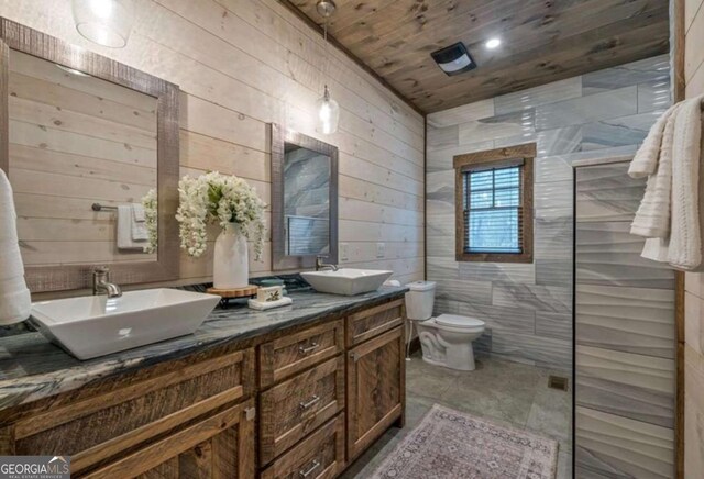 full bathroom featuring double vanity, wooden walls, toilet, and a sink