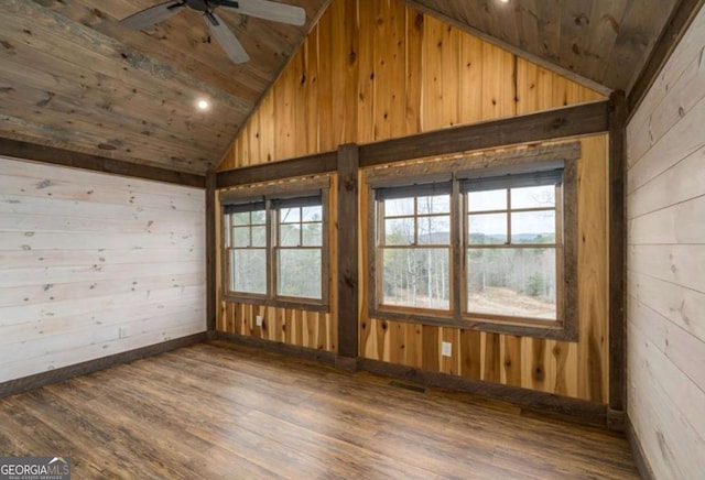 spare room with wood ceiling, vaulted ceiling, and wooden walls