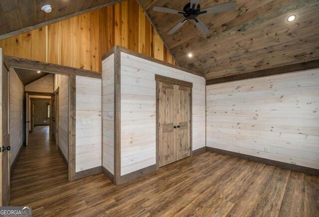 interior space featuring wood walls, wood ceiling, a ceiling fan, and dark wood-type flooring