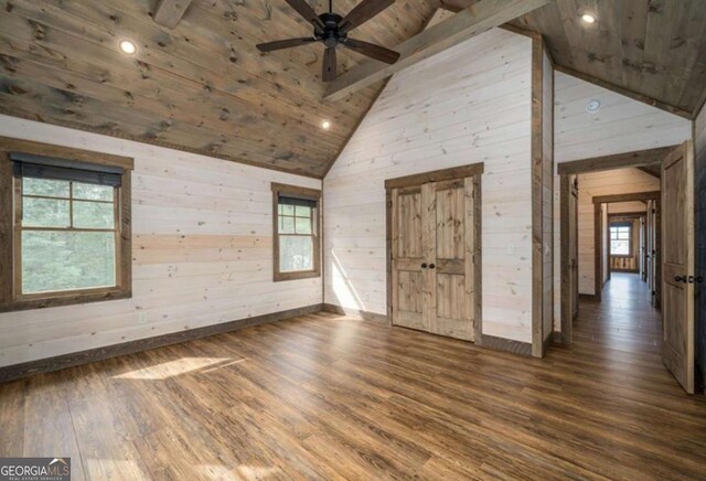 unfurnished bedroom with dark wood-style floors, beam ceiling, wood ceiling, wood walls, and high vaulted ceiling