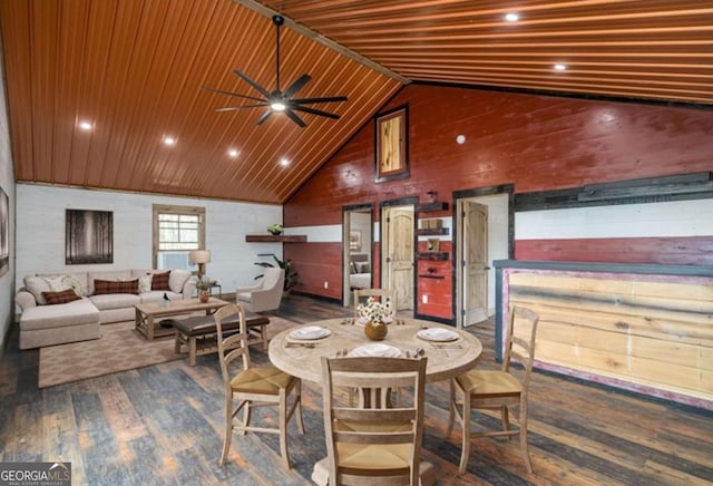 dining space with wooden walls, a ceiling fan, dark wood-style floors, wood ceiling, and high vaulted ceiling