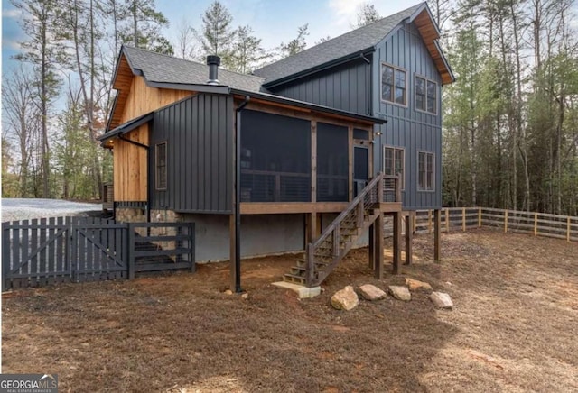 back of house with a shingled roof, fence, and a sunroom