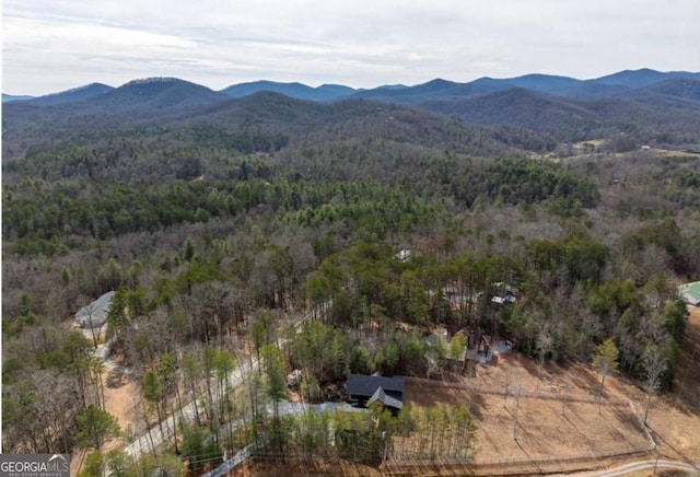 drone / aerial view featuring a mountain view and a view of trees