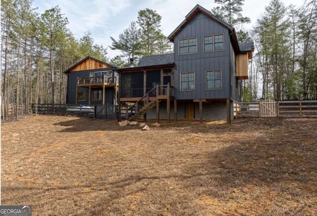 rear view of property with a sunroom, a fenced backyard, stairway, and a deck