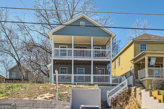 view of front of home featuring a porch, stairway, and a balcony