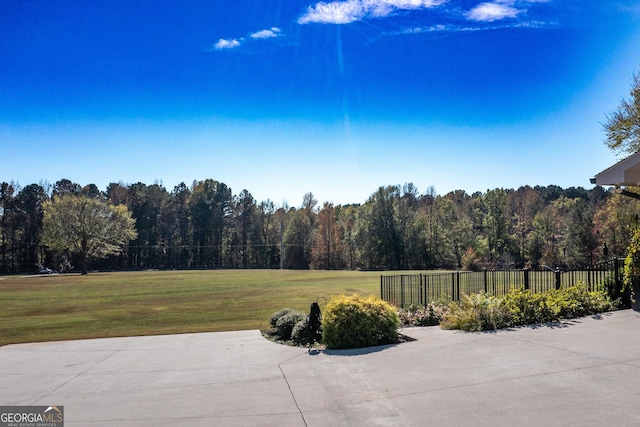 view of patio / terrace with fence and a view of trees