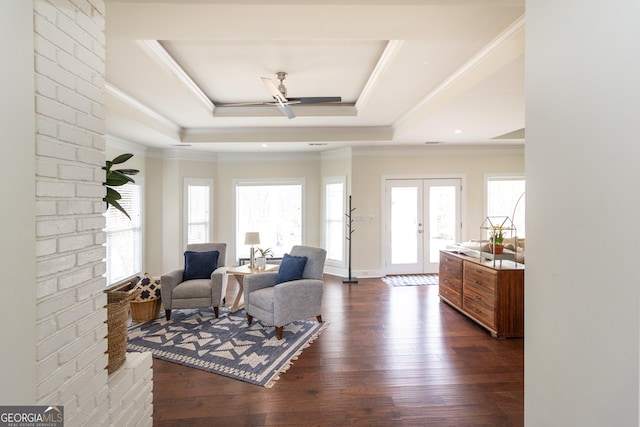 sitting room featuring ceiling fan, dark wood finished floors, french doors, a raised ceiling, and crown molding