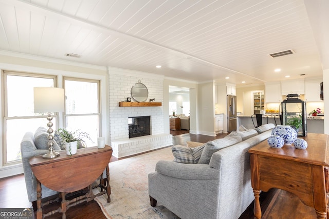 living room featuring plenty of natural light, wood finished floors, and visible vents