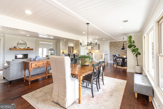 dining space with dark wood-style flooring, a fireplace, and visible vents