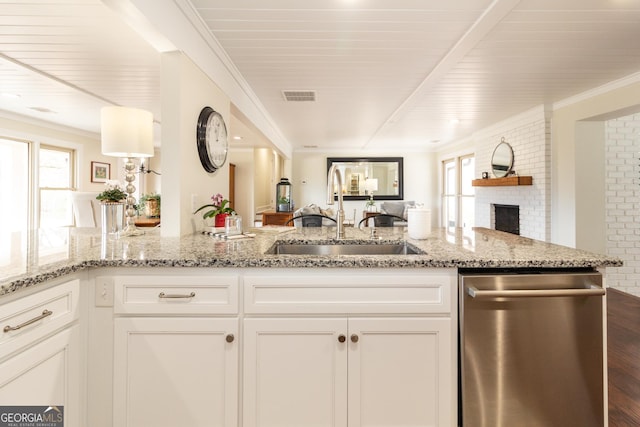 kitchen featuring visible vents, white cabinets, dishwasher, open floor plan, and a sink