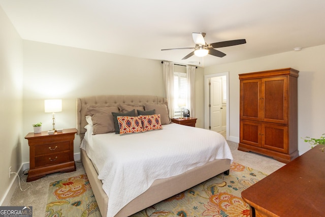 bedroom featuring ceiling fan, baseboards, and light colored carpet