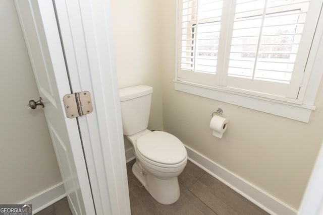 bathroom featuring toilet, baseboards, and tile patterned floors