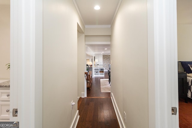 corridor featuring baseboards, dark wood-style flooring, recessed lighting, and crown molding