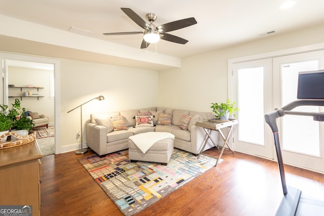 living area with baseboards, ceiling fan, visible vents, and dark wood-type flooring