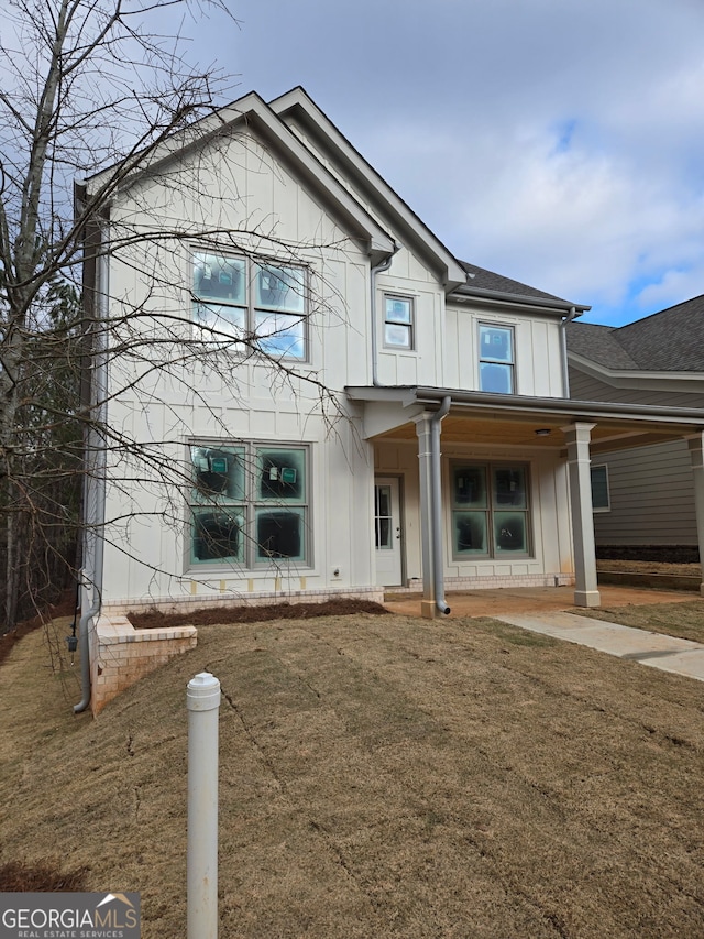 view of front facade featuring a front lawn and board and batten siding