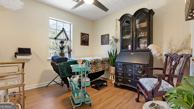 office space with visible vents, ceiling fan, baseboards, and wood finished floors