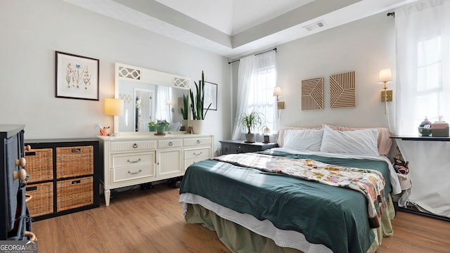 bedroom with light wood-style flooring and visible vents