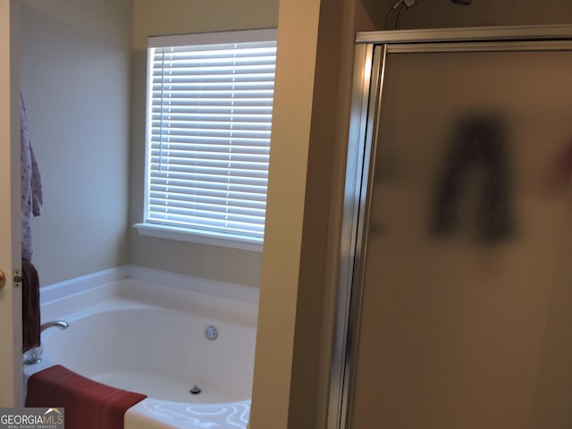 bathroom with a shower stall and a bath