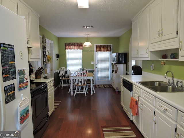 kitchen with stainless steel appliances, light countertops, a sink, and white cabinetry