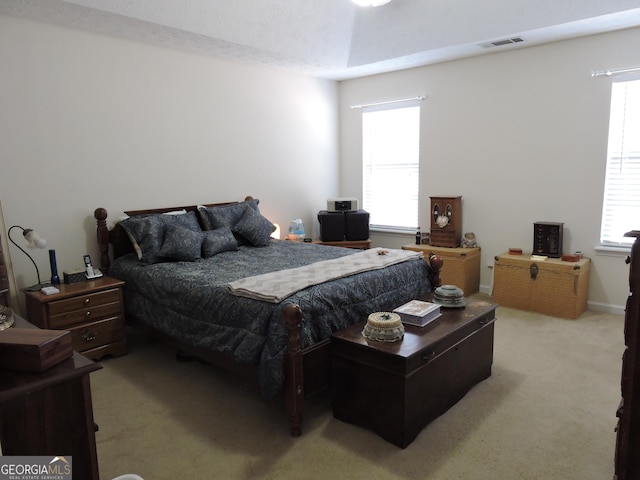 bedroom featuring light carpet, multiple windows, and visible vents