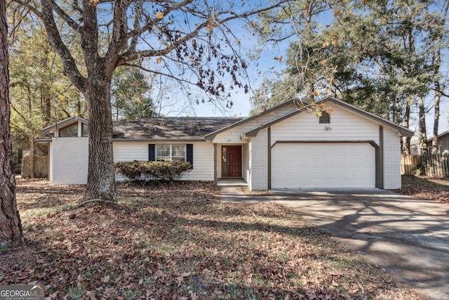 single story home featuring concrete driveway, brick siding, and an attached garage