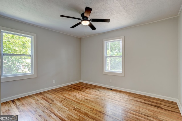 unfurnished room featuring visible vents, baseboards, a textured ceiling, and light wood finished floors