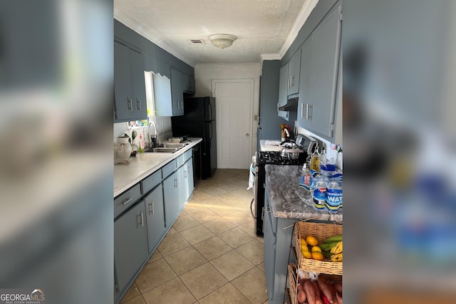 kitchen featuring light countertops, visible vents, light tile patterned flooring, a sink, and gas range