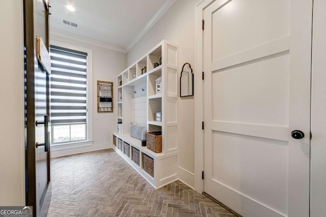 mudroom featuring ornamental molding, visible vents, and baseboards