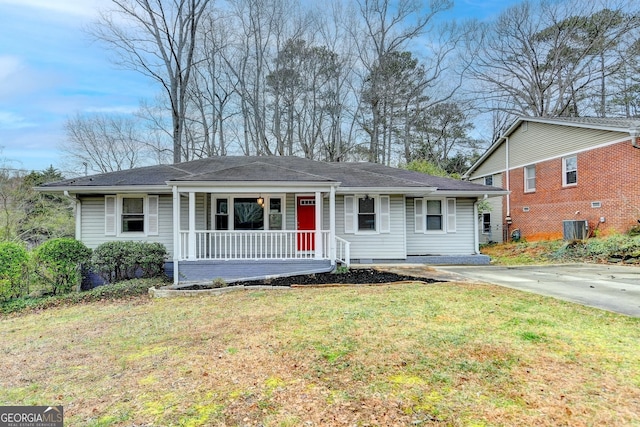 view of front of house with central AC, driveway, a porch, and a front lawn