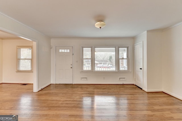 entrance foyer featuring light wood-style floors, baseboards, and ornamental molding