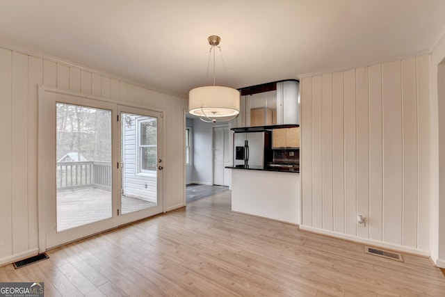 interior space featuring light wood-style flooring, visible vents, and ornamental molding