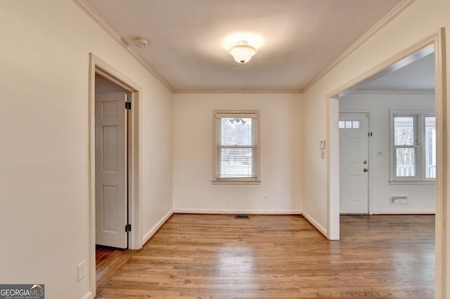 foyer featuring light wood-type flooring, baseboards, visible vents, and crown molding